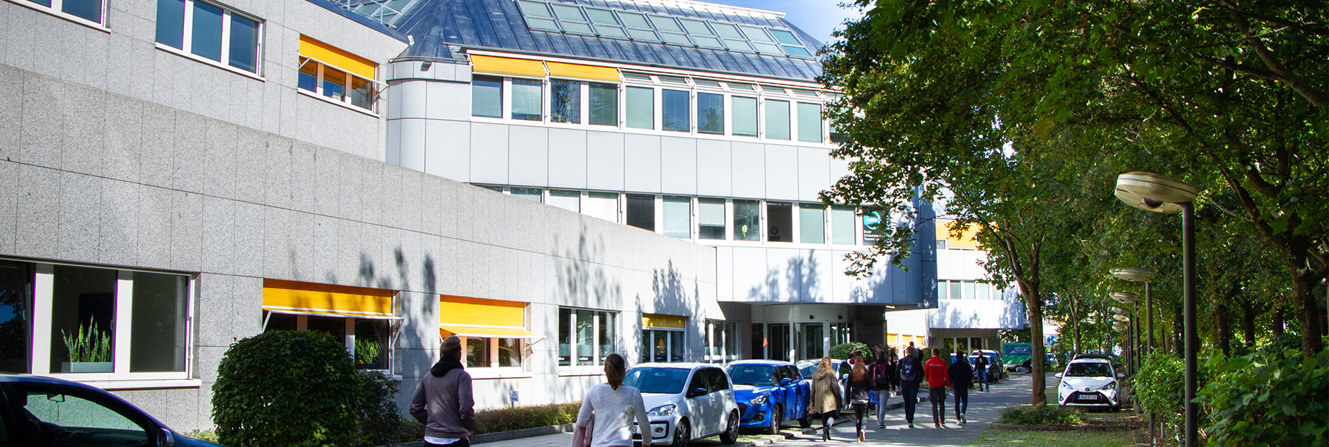 Studenten gehen zum Eingang des Ismaninger Standortes.