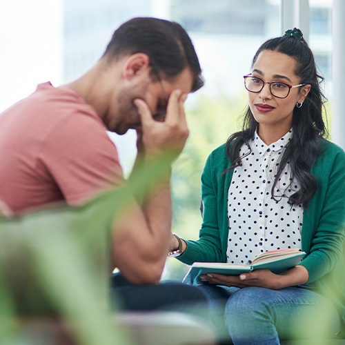 Eine junge Psychologin im Gespräch mit ihrem Patienten.