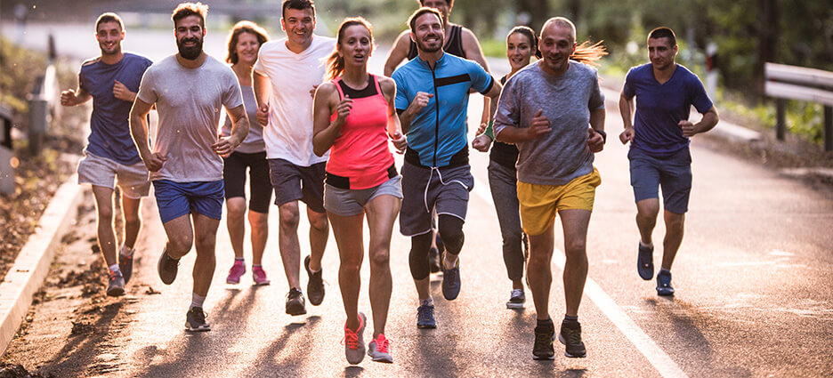 Eine Breitensporttrainerin leitet eine Gruppe beim joggen an.