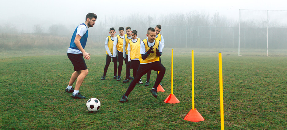 Ein Trainer im Nachwuchsleistungssport macht Koordinationstraining mit seinem Team.