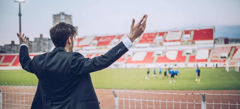 Ein Leiter im Sport- und Verbandsmanagement feuert seine Mannschaft im Stadion an.