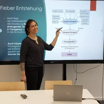 Junge Frau hält Präsentation über Krankheitsentwicklung