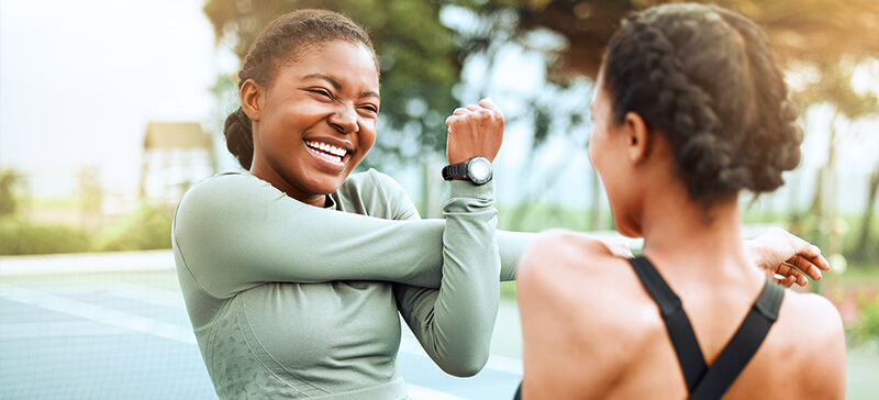 Zwei junge Frauen beim Aufwärmen für ihr Training.