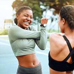 Zwei junge Frauen beim Aufwärmen für ihr Training.