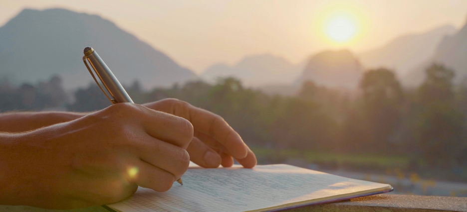 Handschriftliche Niederschrift auf ein Manual mit Ausblick auf die Berge.