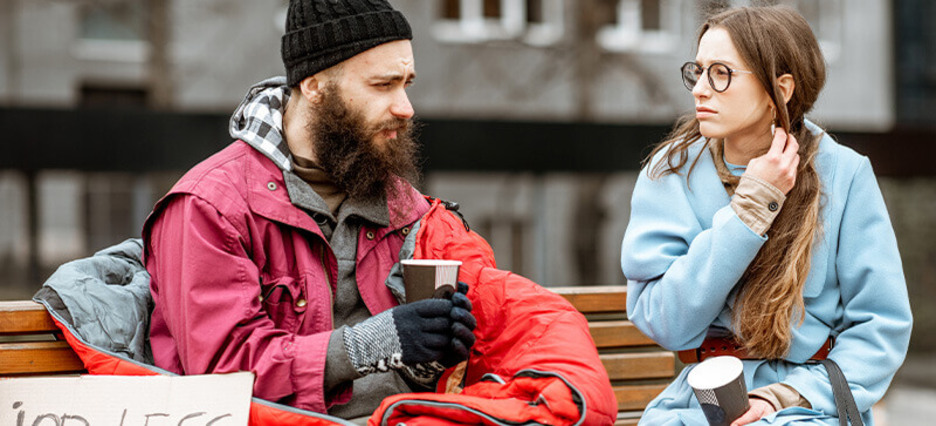 Eine Streetworkerin unterhält sich mit einem wohnungslosem Mann.
