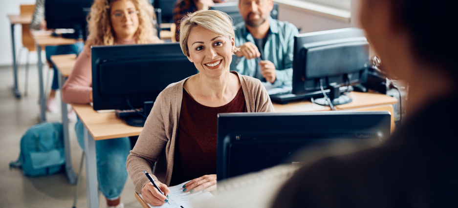Coaching hält einen Vortrag vor einer Gruppe Mitarbeitenden.
