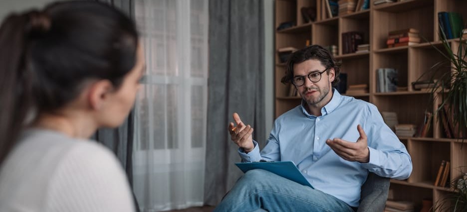 Männlicher Psychotherapeut im Gespräch mit weiblicher Patientin