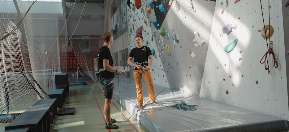 Ein Experte im Gesundheitswesen hilft einen Mann an der Kletterwand.
