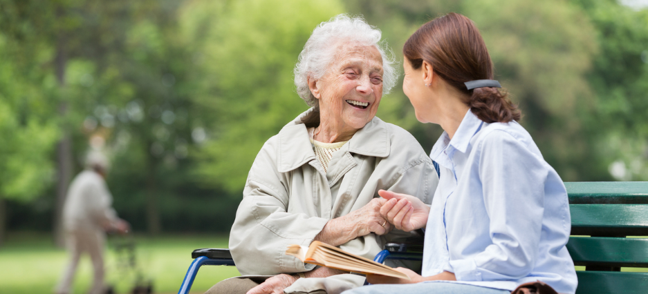 Junge Frau verbringt einen schönen Nachmittag mit einer Seniorin im Park.