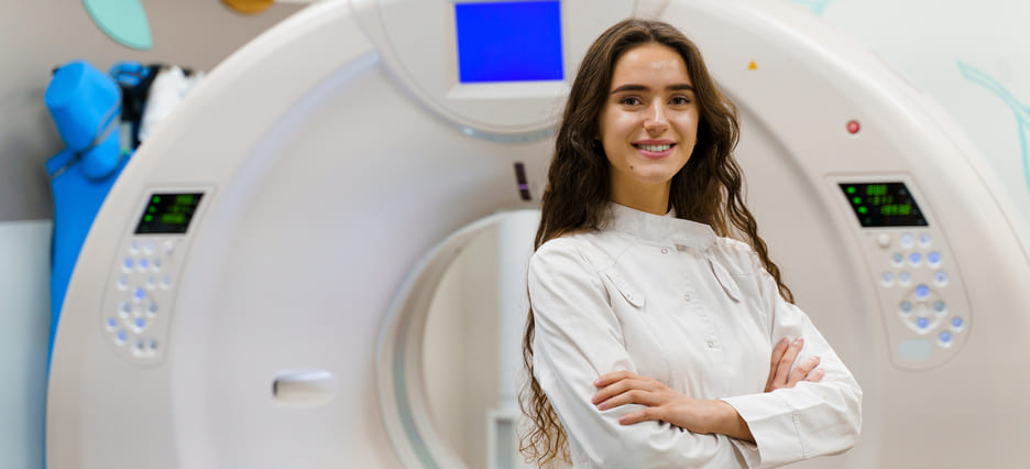 Medizintechnikerin steht vor Kernspintomographen