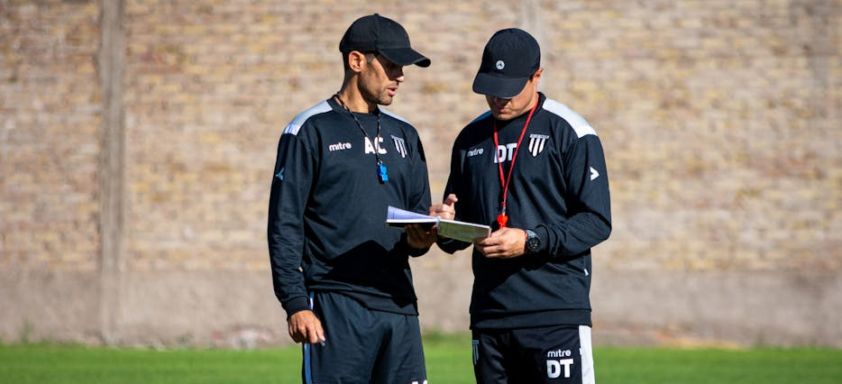 Zwei sportpsychologische Coaches analysieren die Leistung der Fußballspieler während der Partie.