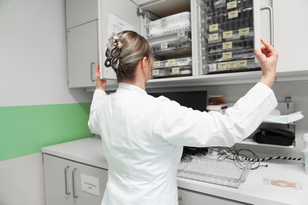 PA holt Instrumente aus dem Materialschrank, um Patienten zu verarzten