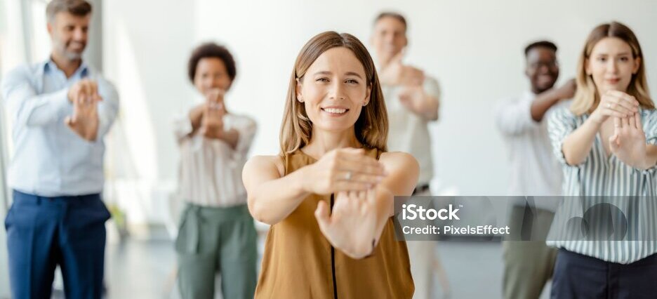 Multiethnic young office employees do workout exercises during break at work